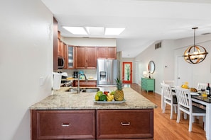 The fully equipped kitchen and the adjoining dining area create a harmonious environment that enhances the joy of cooking and the pleasure of shared meals.