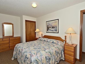 Cozy bedroom with a queen-sized bed, warm decor, and ample storage.