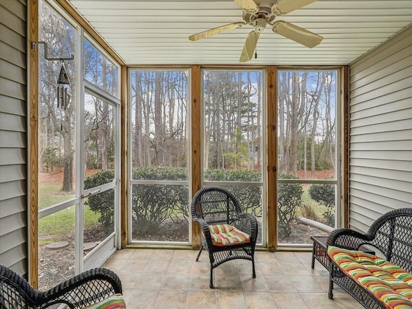 Visibility from the screened porch reveals a tranquil landscape, enhancing the townhome's coastal-inspired ambiance and providing a seamless connection to nature.