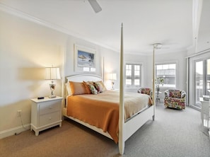 Luxurious comfort continues in the master bedrooms, each adorned with cozy accents and windows that invite natural light, perfect for unwinding after a day at the beach.