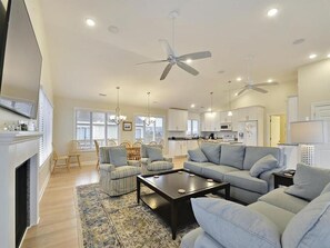 The open-concept living area features updated appliances and comfortable seating, perfect for family gatherings after a day at the beach.