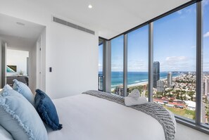 Master bedroom with a plush king bed—wake up to sweeping views of the ocean blue right from your pillow.