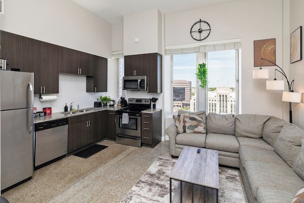 Living room and kitchen area w/ incredible view, sectional couch, smart TV and all kitchen appliances
