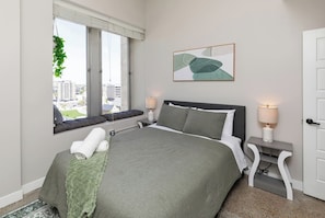 Bedroom 2 with queen bed, Roku smart TV, nightstand chargers, closet and amazing view!