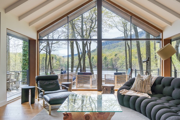 Massive windows in the living room reveal breathtaking views of the Shawangunks and private lake below.