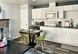A stylish kitchen and dining area with a table and chairs, providing a comfortable setting for dining and socializing.