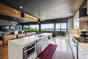 Kitchen: Enjoy panoramic city views from our airy living room with floor-to-ceiling windows, modern amenities, and a cozy gas fireplace.