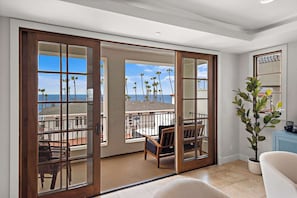 The living room has lots of comfortable seating, views and natural light pouring in from the balcony.