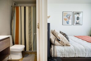 Relax in this cozy bedroom with modern art and unwind in the stylish bathroom with a vibrant shower curtain.