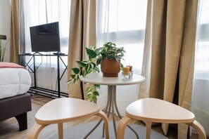 Cozy bedroom nook with natural light, perfect for relaxing with a book or enjoying a morning coffee.
