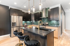 2nd Floor: Fully Equipped Kitchen with stainless steel appliances and a spacious island with seating.