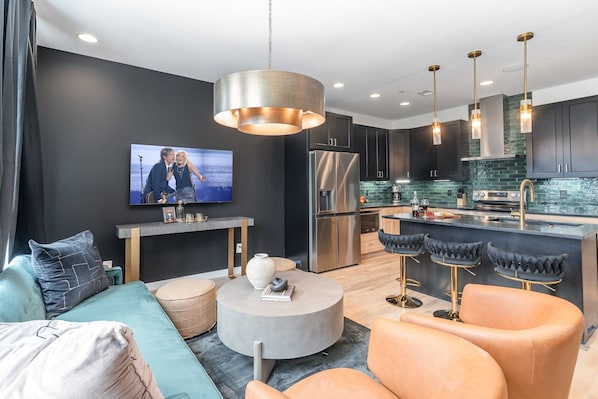 2nd Floor: Open-concept living area featuring a Smart TV, cozy armchairs, and a comfortable sofa.