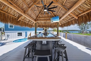 Enjoy this Tiki Bar that seats 12 with surround sound tv and light features to maximize night time fun!