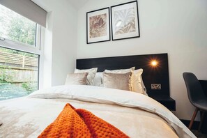 Modern bedding, neutral tones, and soft textures create a relaxing sleep space