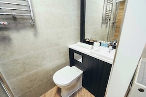 Relax in a spotless bathroom featuring a refreshing shower, complimentary toiletries, and soft towels