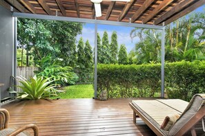 Unwind on the rear patio. Large sun lounges overlook the lush green garden, creating an idyllic spot for a midday nap.