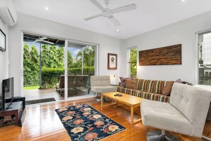 Relax in the living space downstairs. It’s fitted with plush sofas surrounding a TV and opens directly to the patio.
