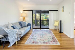 The living room opens up to the balcony and comes with a comfortable sofa to relax at the end of the day.
