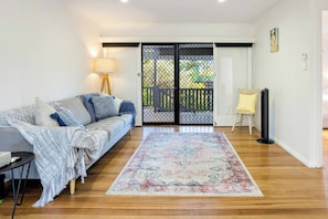 The living room opens up to the balcony and comes with a comfortable sofa to relax at the end of the day.