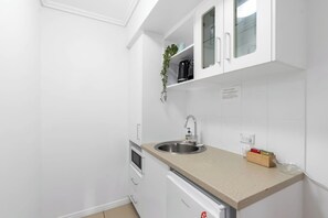 Tucked near the entry, the kitchenette is perfect for prepping light meals or morning coffee, with a microwave, sink, and mini fridge at your fingertips.