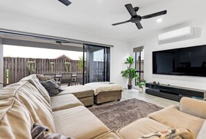 This inviting living area blends comfort and style effortlessly, complete with air conditioning and ceiling fans to keep things cool and relaxed.