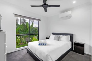 Unwind in the second bedroom with a queen bed, lush greenery views, a TV for laid-back evenings, and a tallboy for keeping things tidy.