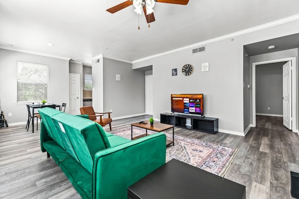 Bright and airy living room with plush seating, a large TV, and tasteful decor, creating the perfect space for relaxation and entertainment.