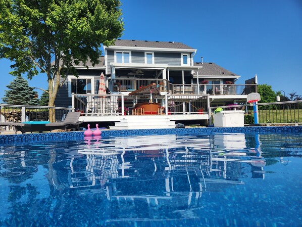 Back of house with pool and hot tub