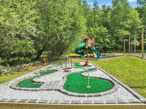 The backyard features a four-hole miniature golf course and large play-set
featuring two slides, a climbing wall, and swings.