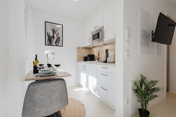 Enjoy your meals at the stylish dining table with a view of the modern kitchenette and TV. Küchenzeile ist komplett ausgestattet mit Ceranfeld, Mikrowelle, Kaffeemaschine, Toaster