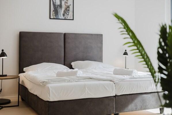 Helles, modernes Schlafzimmer mit bequemen Betten und elegantem Design für einen entspannten Aufenthalt.
