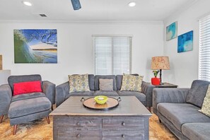 Large living and dining room on the 2nd level connects to kitchen. Custom artwork and access to patio.