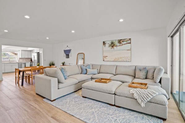 Living Room in unit 1, Relax on the Large Sectional while watching a movie on the 65 inch tv after a long day at the beach. 