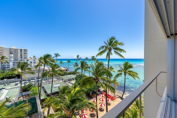 Gorgeous balcony views overlooking the iconic palm-fringed sands of Kaimana Beach—perfect for morning coffee or sunset reflections.