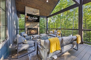 Experience outdoor living at its finest with a fireplace and comfy seating on this spacious covered deck, perfect for all-weather enjoyment.