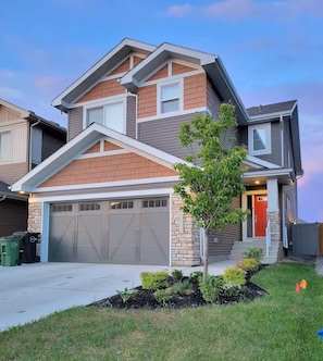 Warm and welcoming exterior at dusk with glowing lights and modern curb appeal.
