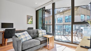 An open-plan living/dining space that seamlessly extends to a covered balcony