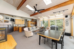From the cozy sectional to the dining table, this open layout ensures everyone feels connected while enjoying the beautiful surroundings visible through the large windows.