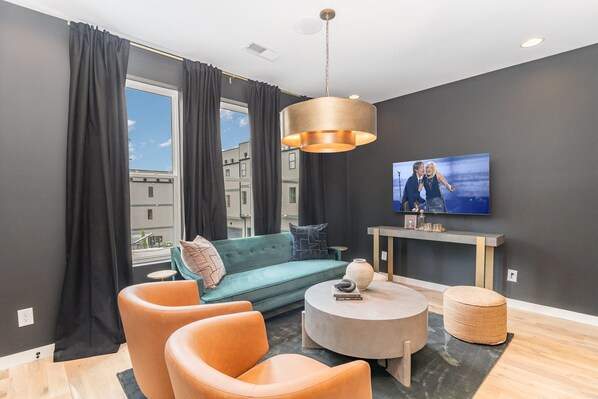 1st Unit (2nd Floor): Open-concept living area featuring a Smart TV, cozy armchairs, and a comfortable sofa.