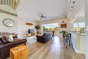 Gather, relax, and take in the view—this airy living area opens right onto the water-facing deck!