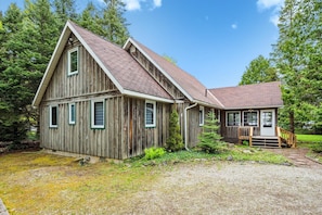 Lakeview Loft’s iconic A-frame design features soaring wood-clad ceilings and a warm, welcoming exterior that blends beautifully into the forested surroundings.