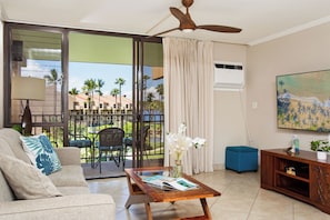 Living room with 65" Smart TV, Pull-out sleeper sofa, Ceiling fan, and Window AC