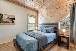 Upstairs bedroom 2 has a queen bed with shelving in the closet for clothes