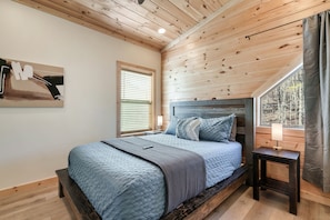 Upstairs bedroom 2 has a queen bed with shelving in the closet for clothes