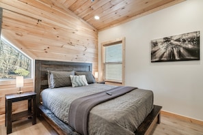 Upstairs bedroom 1 has a queen bed with shelving in the closet for clothes