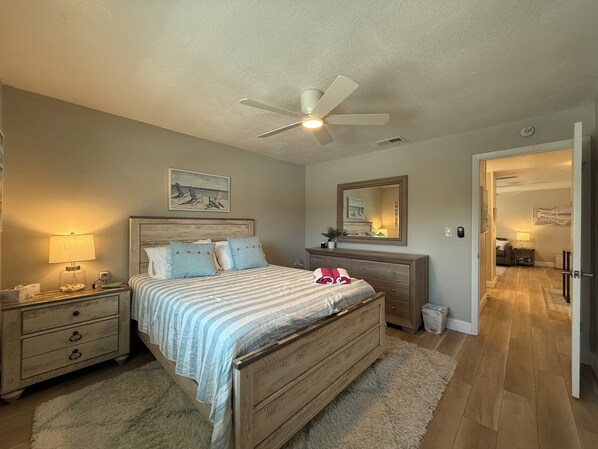 Features a Queen-sized bed, nightstand, ceiling fan, closet, dresser with mirror