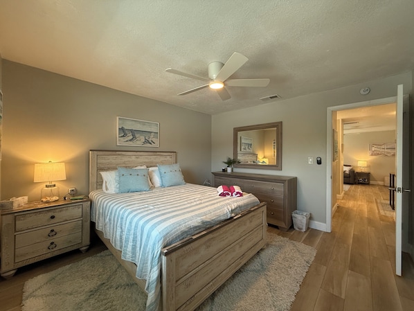 Features a Queen-sized bed, nightstand, ceiling fan, closet, dresser with mirror