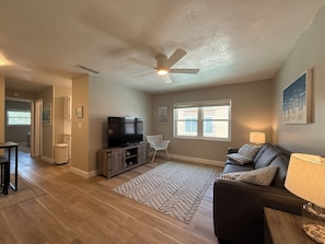 Open concept Living and Dining Area. Features a sofa-bed, ceiling fan, and a TV