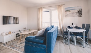 Stylish living room with TV and dining area – Brisa combines modern design with functionality, perfect for longer seaside stays.