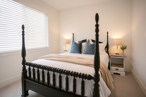Elegant four-poster bed framed by warm light and plush pillows—perfect for a peaceful night’s rest.